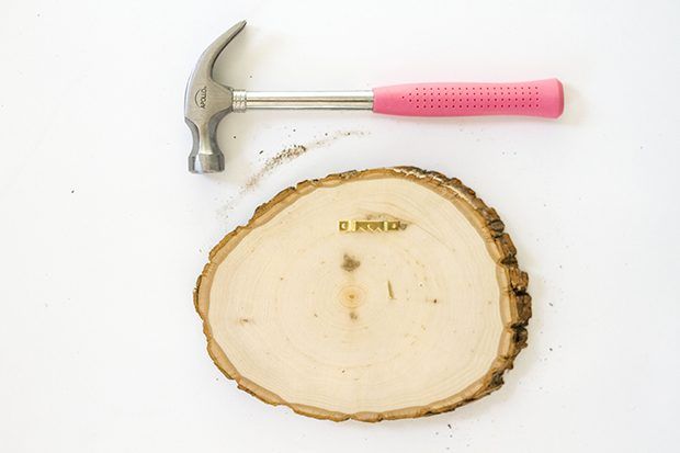 Utilisez un marteau pour fixer le matériel photo-suspension à l'arrière de la dalle de bois.