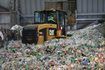 Tracteur conduit à travers énorme tas de bouteilles en plastique au centre de recyclage de San Francisco.