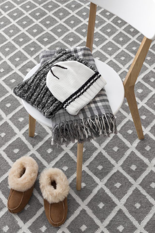 Close-up d'un bonnet de laine et une écharpe portant sur une chaise.