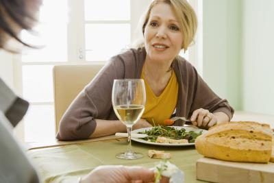 Femme à la table de dîner avec un verre de vin